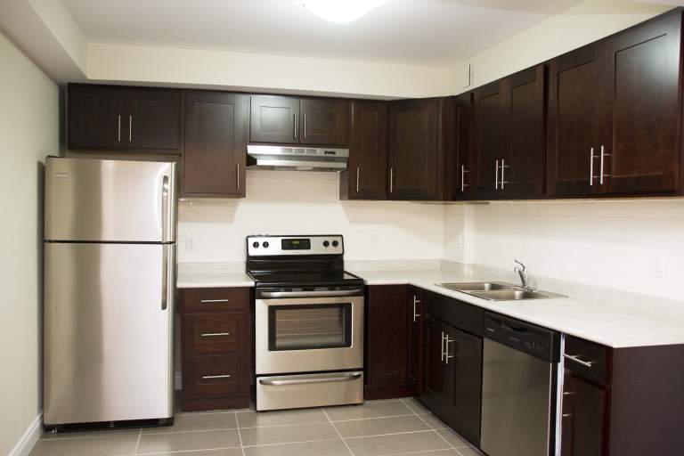 Renovated kitchen with stainless steel appliances and dark brown cabinets