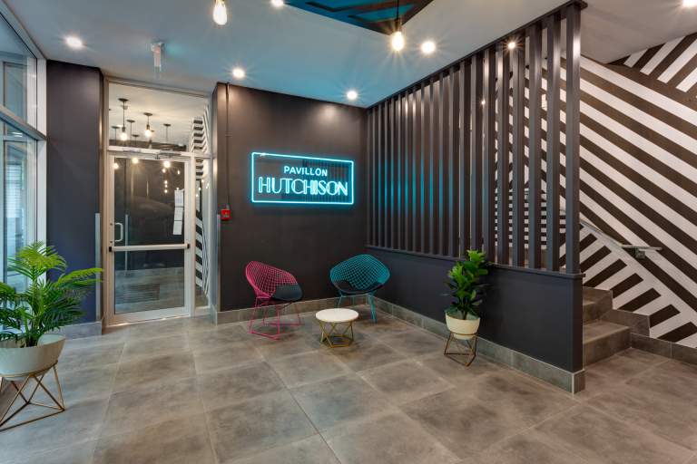 Lobby at Pavillon Hutchison with neon sign and seating