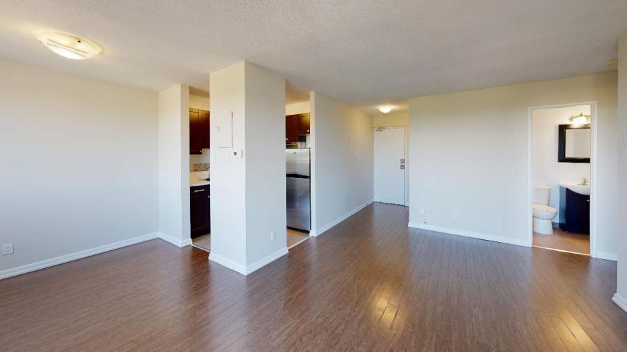 Bright and spacious living room with laminate floors and kitchen