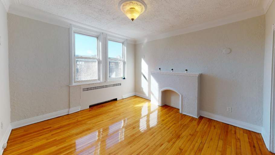 Bright and spacious living room with hardwood floors, fireplace, and heater